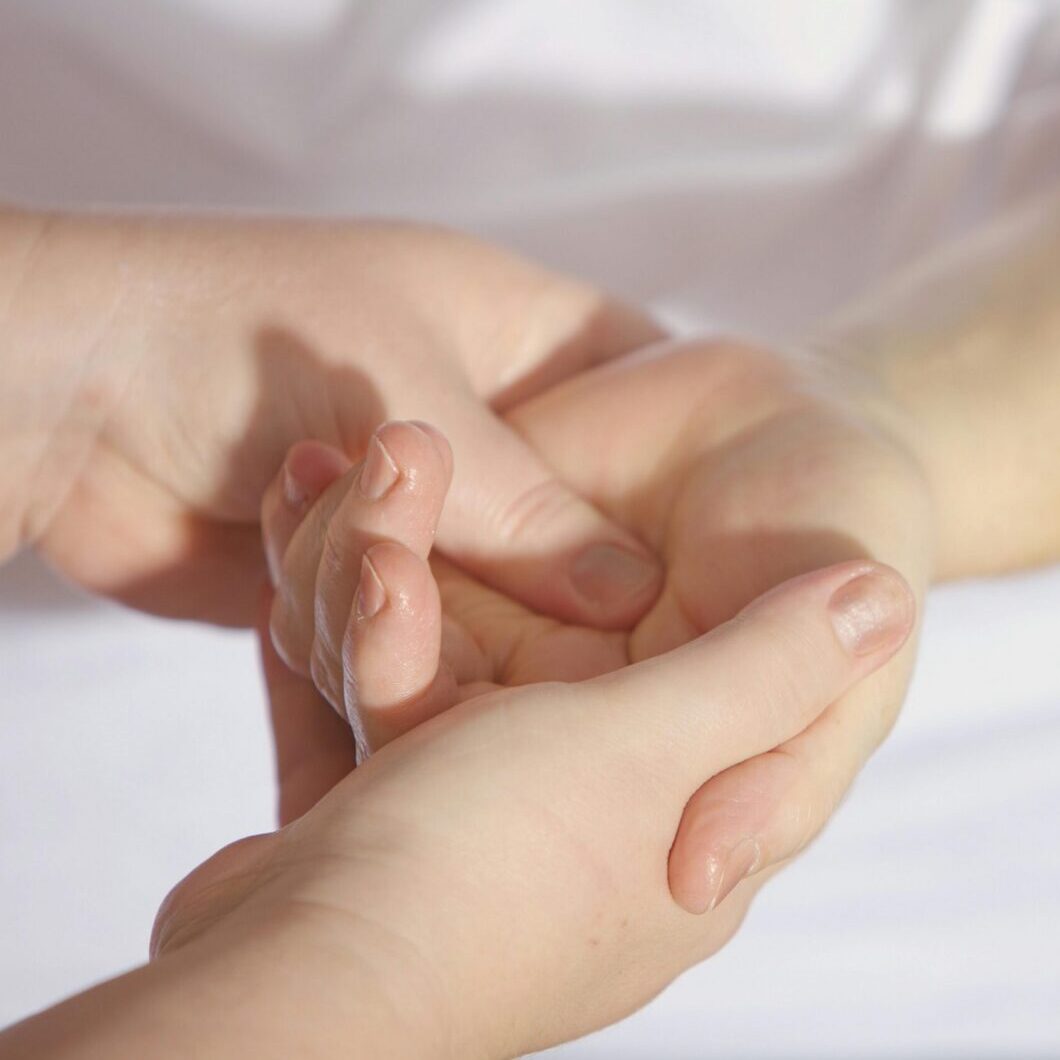 Close-up of a manicure being performed with a nail file on a hand.