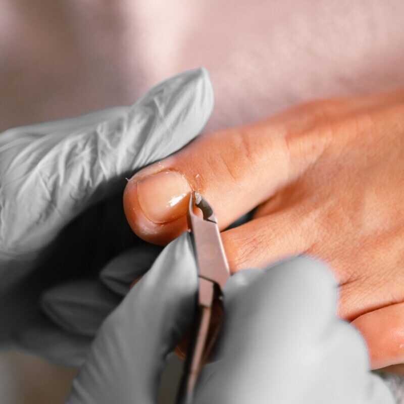 Close-up of a manicure being performed with a nail file on a hand.