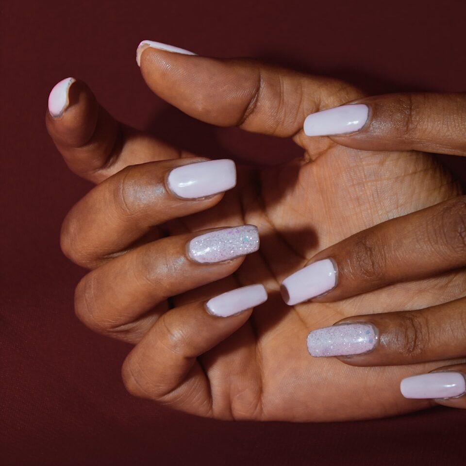 Close-up of a manicure being performed with a nail file on a hand.