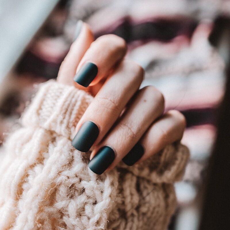 Close-up of a manicure being performed with a nail file on a hand.