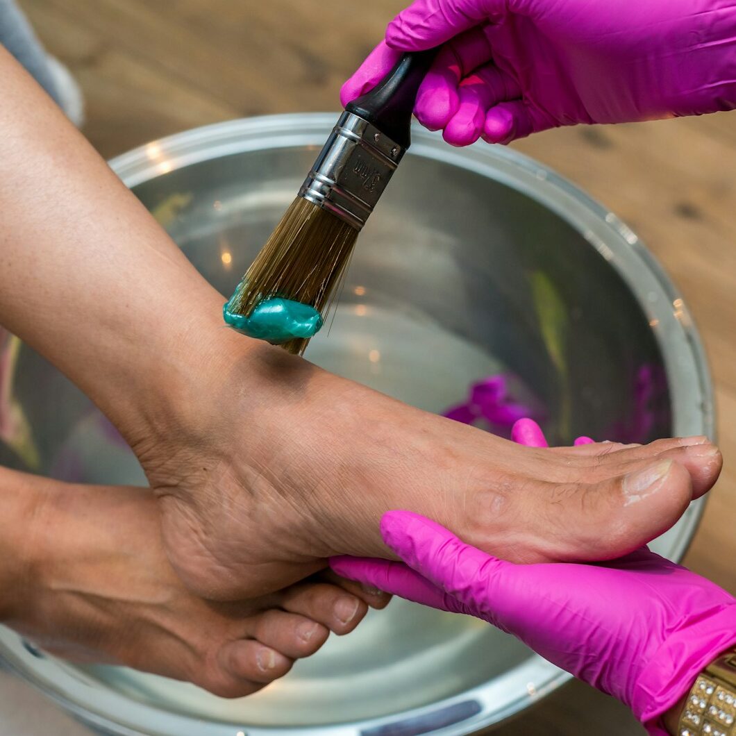 Close-up of a manicure being performed with a nail file on a hand.